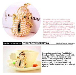 Detail of golden frog keychain with white pearls and green rhinestones, 10.5cm total length