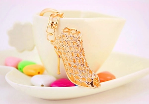 Close-up of golden hollow crystal high heel keychain on a heart-shaped cup handle