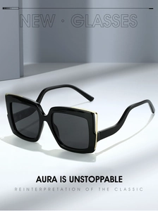 Detail of oversized black square sunglasses with gold metal accents on the hinges