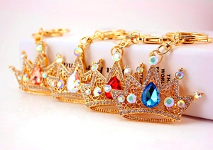 Close-up of sparkling crystal crown keychains in blue, red, orange, and iridescent colors
