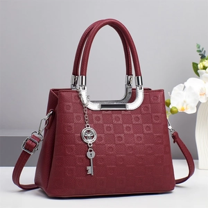 Sac à main bordeaux en cuir gaufré avec bandoulière et pendentifs en métal argenté