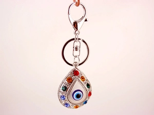 Detailed view of silver evil eye teardrop keychain with colorful rhinestones on white background