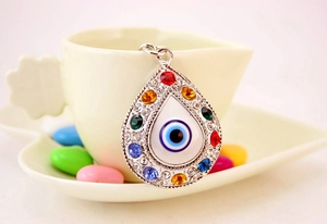 Macro shot of silver teardrop evil eye keychain with vibrant colorful rhinestones