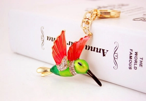Macro view of a colorful hummingbird keychain with red enamel wings and sparkling rhinestones