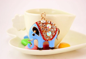 Detailweergave van blauwe emaille olifant sleutelhanger met strassteentjes in harttray