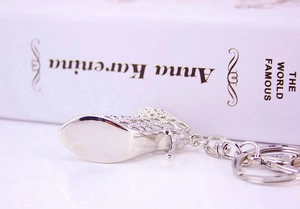 Macro shot of silver hollow high heel shoe keychain accessory with polished metal finish