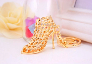 Close-up of golden metal high heel keychain with elegant hollow mesh design