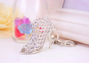 Detail of silver hollow high heel shoe keychain accessory with a polished metal finish