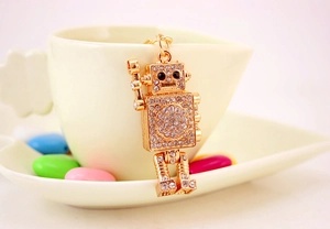 Macro shot of gold-plated robot keychain with sparkling rhinestones and black gem eyes