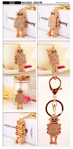 Detailed views of gold robot keychain with white crystals and sturdy lobster clasp