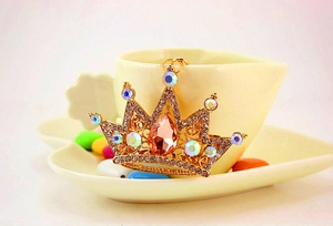 Detail of crown keychain featuring a teardrop orange gemstone and crystal pavé