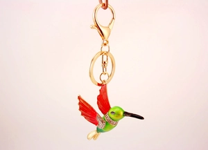 Detailed macro view of hummingbird keychain with red green enamel and rhinestones