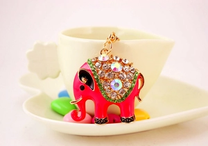 Detail van roze emaille olifant sleutelhanger met strass op wit hartvormig bordje