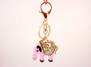 Detailopname van roze olifant sleutelhanger met groene strass steentjes op gouden ketting