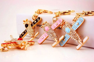 Detailed set of four rhinestone airplane keychains in black, pink, blue, and red colors
