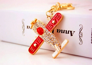 Macro view of crystal helicopter keychain with red body and gold accents on a book
