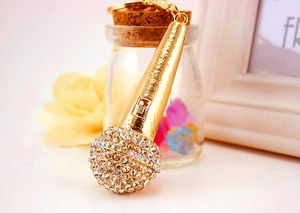 Detail shot of golden microphone keychain with sparkling rhinestones and textured handle