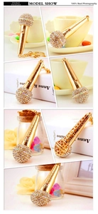 Detail view of gold microphone keychain with sparkling rhinestones and star cutout design
