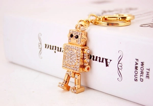Detailed close-up of golden robot keychain with sparkling rhinestones and lobster clasp