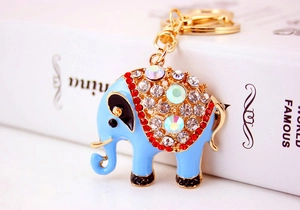 Detail van blauwe emaille olifant sleutelhanger met glittersteentjes en goudkleurig metaal