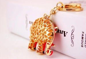 Gedetailleerde weergave van een gouden olifant sleutelhanger met rode voering en patronen