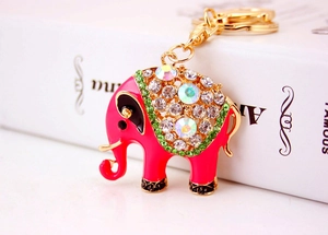 Detailopname van een roze olifant sleutelhanger met strass op een wit boek