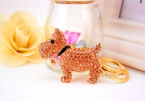 Close-up of a sparkling gold dog keychain with rhinestones and a small bell charm