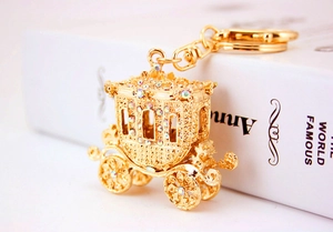 Detailed close-up of golden pumpkin carriage keychain with shiny crystals and metal finish