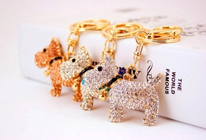Three creative rhinestone puppy keychains with small bells in gold and silver finishes