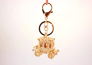 Close-up of golden pumpkin carriage keychain with sparkling rhinestone detailing