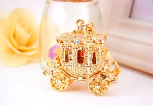 Macro shot of gold-tone pumpkin carriage keychain with sparkling rhinestone detailing