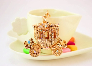 Detailed macro view of a gold pumpkin carriage keychain with sparkling rhinestones