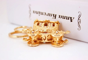 Detailed macro view of a golden pumpkin carriage keychain with shiny crystal rhinestones