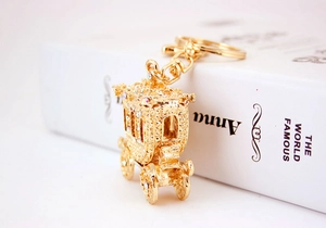 Close-up of a luxury gold pumpkin carriage keychain with sparkling rhinestones details
