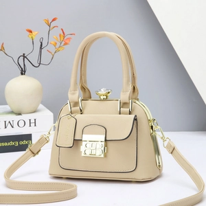 Elegante bolso de mano beige en cuero texturizado con detalles metálicos dorados