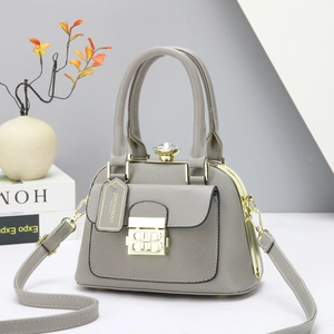 Elegante bolso de mano gris con forma de concha, textura de cuero y hebilla dorada