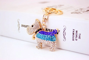Detailed view of a golden puppy keychain encrusted with clear and blue rhinestones