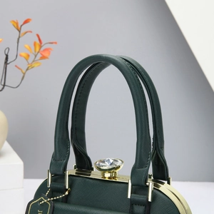 Detalle del bolso de piel Saffiano verde oscuro con herrajes dorados y hebilla cristal