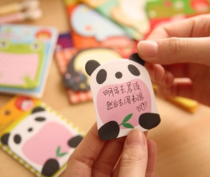 Close-up of cute panda-shaped sticky notes with pink writing area and green bamboo leaves