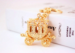Close-up of golden alloy pumpkin carriage keychain with sparkling rhinestones decoration