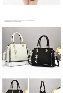 Detail of elegant crocodile pattern leather handbags with gold hardware and pearl charm
