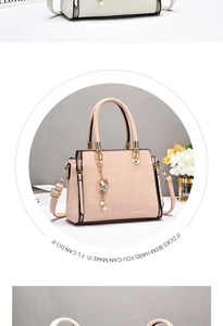 Close-up of pink faux crocodile leather texture and golden metal hardware on handbag