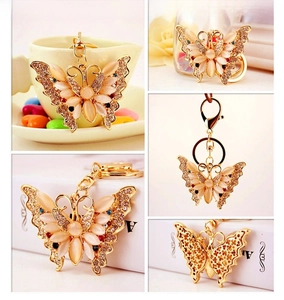 Detailed views of a gold butterfly keychain with cat eye stones and sparkling rhinestones
