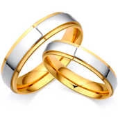 Macro detail of two-tone gold and silver stainless steel rings with walnut wood inlay