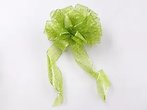 Close-up of glittery mesh Christmas bows and colorful fabric rolls for festive DIY decor