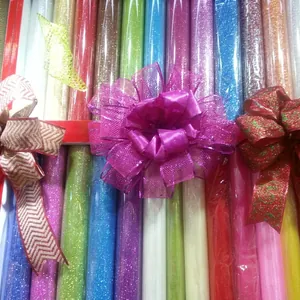 Macro detail of glitter Christmas ribbon rolls and decorative bows in assorted festive colors