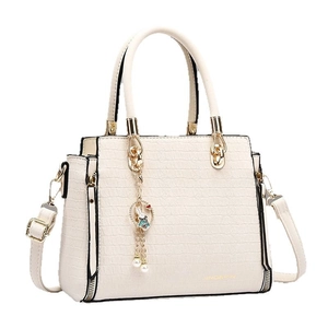 Elegant cream crocodile-patterned handbag with golden hardware and cute bunny charm accessory