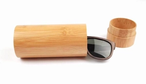 Detail of eco-friendly cylindrical bamboo sunglass case with wooden polarized sunglasses