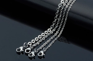 Detail of four stainless steel hammer cross chains in varying thicknesses with lobster clasps