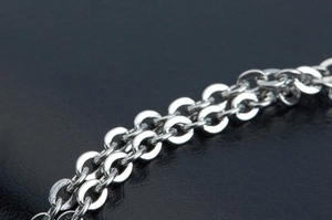 Close-up of polished silver stainless steel cross chain with interlinked double rings